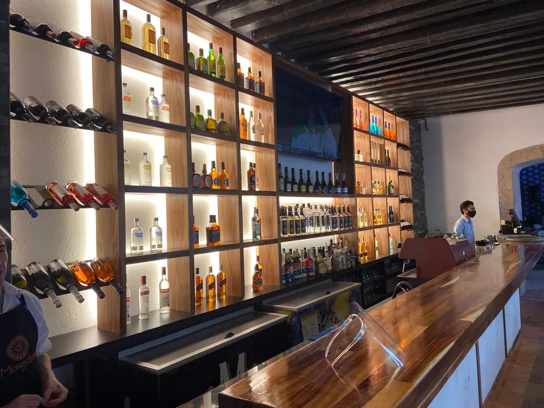 Cava de vinos y licores con iluminación cálida por repisa